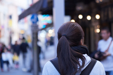 都会の街を歩く女性の後ろ姿