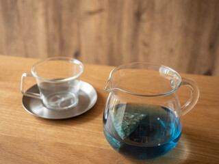 青い色のハーブティーとカップ