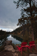 Red chairs facing lake at the Valley of the five lakes in Canada