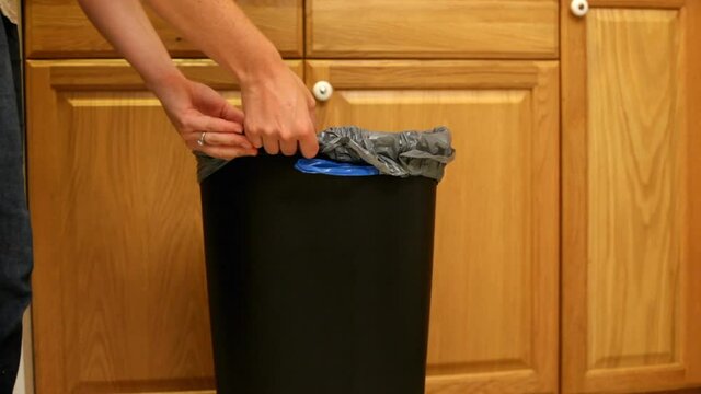 Taking Out Trash Bag From Kitchen Garbage Can