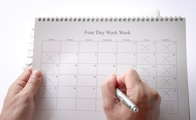 Man holding a calendar with four day work week concept. Fridays, Saturdays and Sundays are crossed.