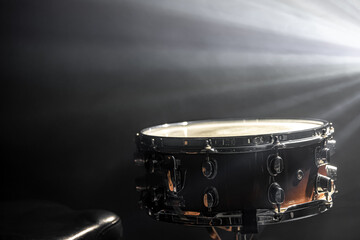 Fototapeta na wymiar Snare drum on a black background with stage lighting, copy space.