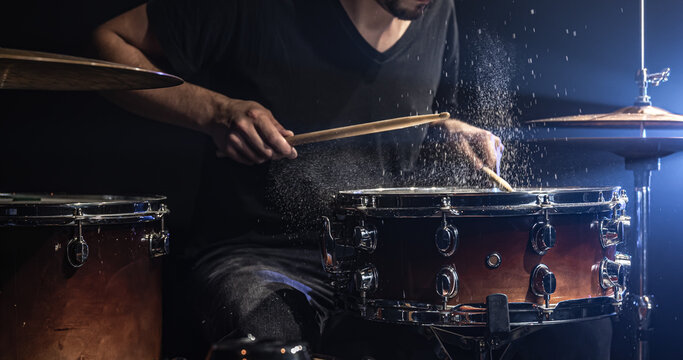 The drummer plays the snare drum with splashing water.