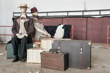  Theater decoration requisites and props, mannequins sitting on the vintage leather suitcases