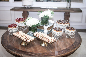 Mesa de banquete con aperitivos, pasteles dulces de colores con chocolate y crema. 