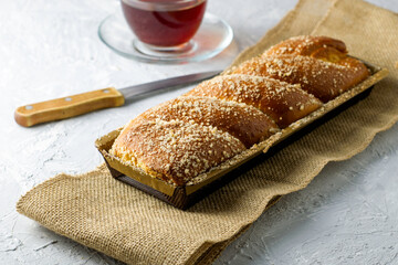 cherry-vanilla strudel knife and a cup of tea on a light gray surface