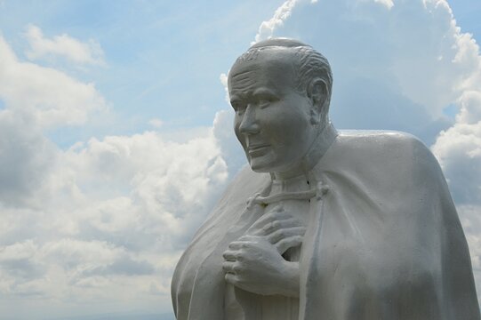 Detail of statue of Pope John Paul The Second, located on Grapa hill near Klin village, Namestovo district, northern Slovakia. Cloudy summer skies in background.