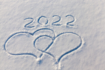 the inscription about the new year 2022 on the snow in winter