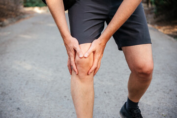 A man athlete suffering from knee pain due IT band syndrome - obrazy, fototapety, plakaty