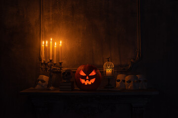 Scary laughing pumpkin and old skull on ancient gothic fireplace. Halloween, witchcraft and magic.