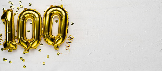 golden foil balloon number one hundred. Birthday or anniversary card with the inscription 100. gray concrete background. - obrazy, fototapety, plakaty