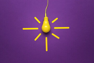 Vintage lamp on a wire on a purple background. Minimalism. Flat lay.