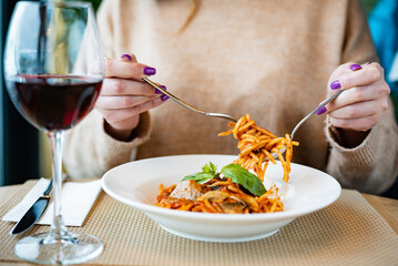 woman eating pasta in restaurant
