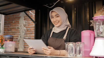 beautiful smiling asian waitress carrying menu list in cafe booth container