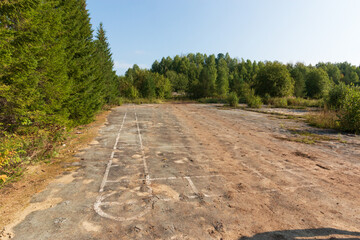 abandoned and overgrown territory with asphalt
