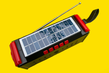 solar panels on radio electronics, antennas and bluetooth speakers with yellow background
