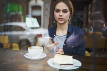 pretty woman sitting at a table in a cafe pensive look
