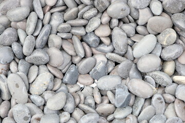 Background of decorative light-grey small polished rocks