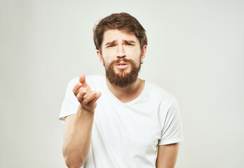 bearded man in a white t-shirt hand gestures anger close-up