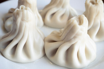 Boiled khinkali or Caucasian dumplings on a ceramic plate, close-up of boiled khinkali with steam