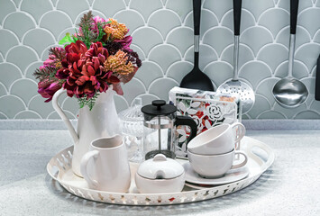 Tray with a coffee set, a French press and a vase of flowers.