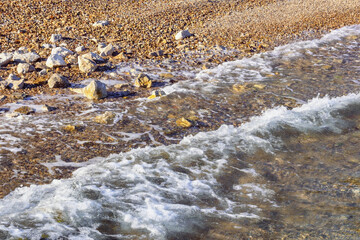 Seaside on a calm sunny day. Pebble beach of the Adriatic Sea, Montenegro