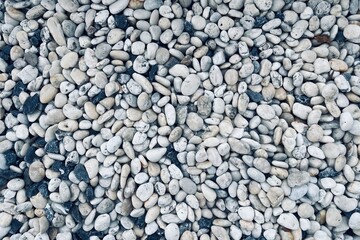 Smooth round pebbles texture background. Pebble sea beach close-up, dark wet pebble and gray dry pebble. 