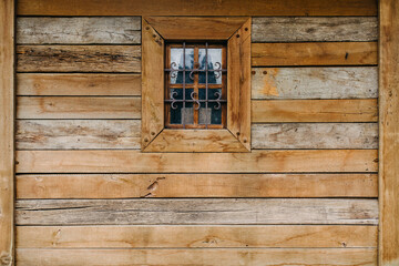 Obraz na płótnie Canvas Old wooden house wall with a small window.