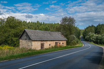 An ancient stone shed in a road mael.
