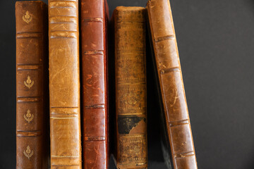 Row of old books on dark background