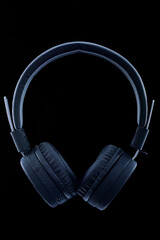Fototapeta na wymiar black wireless headphones on a black background