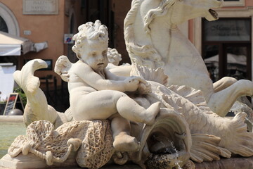 Neptune Fountain Sculpted Detail with Angel and Gushing Fish at Piazza Navona in Rome, Italy