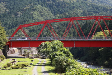 山の緑と赤の鉄橋
