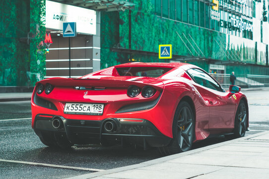 Red Ferrari F8 Spider parked on the street in Moscow. Supercar in front of office building