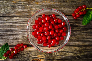 Dessert - fresh redcurrants in bowl on wooden table