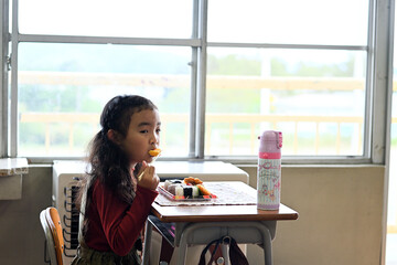 給食を食べる小学生