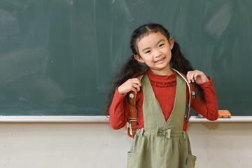 教室の黒板の前の小学生