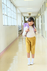 学校の廊下でランドセルを背負った女の子