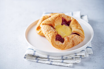 Vanilla cream raspberry jam sweet bun in a plate