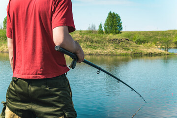 A fisherman is fishing in a red T-shirt. Close-up