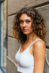 Fototapeta premium vertical portrait of an attractive young woman with curly hair looking at camera