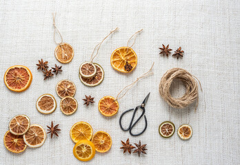 Weihnachtsschmuck getrocknete Orangenscheiben und Anis, Flatlay mit Schere und Bindfaden