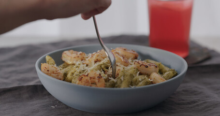 eat penne pasta served with shrimps in blue bowl closeup