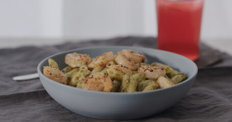 boiled penne pasta served with shrimps in blue bowl closeup