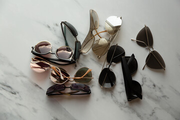 Sun glasses,  many different shapes. On a marble background.