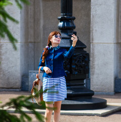 Happy woman take a selfie photo in the city.