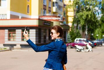 Fototapeta premium Happy woman take a selfie photo in the city.