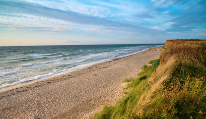 Fototapeta na wymiar Photo of a seascape. Morning sea, sunrise, dunes and hills, beautiful coast and waves.