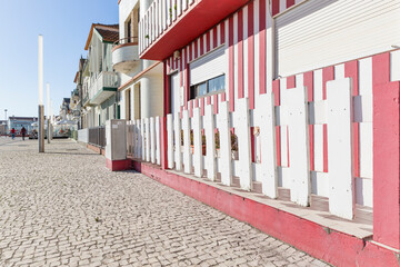 a street with traditional haystacks (houses painted with coloured stripes) at Costa Nova do Prado, Gafanha da Encarnacao, Ilhavo, district of Aveiro, Portugal