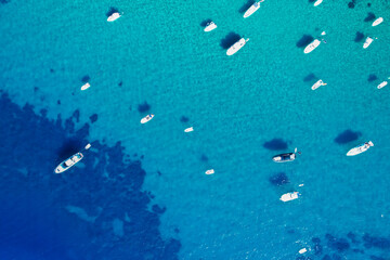 Fototapeta na wymiar View from above, stunning aerial view of a bay with boats and luxury yachts sailing on a turquoise, clear water. Porto Santo Stefano, Italy.